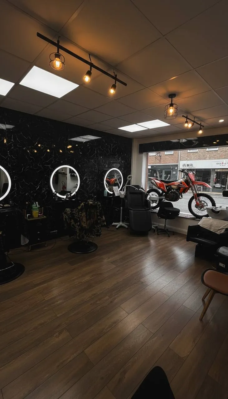 Le salon : murs en marbre noir, miroirs ronds lumineux et motos KTM en vitrine
